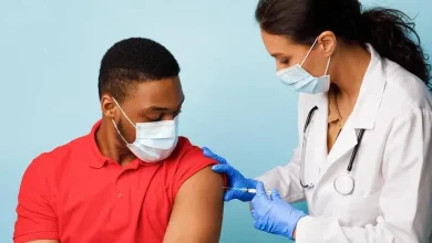 شاب يتلقى لقاح كوفيد-19 في مركز صحي، يوضح أهمية التطعيم ضد فيروس كورونا.