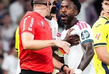 فينيسيوس جونيور لاعب ريال مدريد يبدو مذهولًا أثناء إشهار الحكم البطاقة الحمراء في وجهه خلال مواجهة فياريال، في لقطة تجسد لحظة طرده والجدل حول احتمال غيابه عن مباراة الكلاسيكو أمام برشلونة.