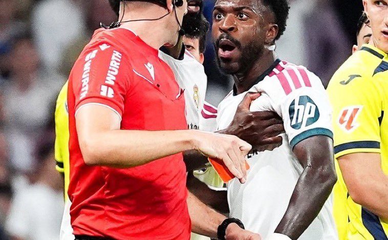 فينيسيوس جونيور لاعب ريال مدريد يبدو مذهولًا أثناء إشهار الحكم البطاقة الحمراء في وجهه خلال مواجهة فياريال، في لقطة تجسد لحظة طرده والجدل حول احتمال غيابه عن مباراة الكلاسيكو أمام برشلونة.