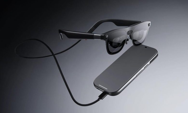 نظارات XREAL AURA الذكية من جوجل وXREAL بتصميم شفاف مع وحدة الحوسبة المتصلة بها عبر كابل، وتدعم نظام Android XR لعرض الشاشات الافتراضية والتطبيقات الرقمية أمام المستخدم.