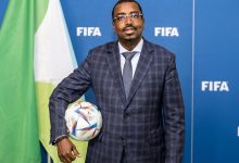 سليمان حسن وبيري رئيس الاتحاد الجيبوتي لكرة القدم خلال ظهور رسمي أمام خلفية تحمل شعار الاتحاد الدولي لكرة القدم فيفا.