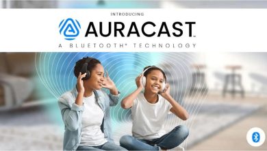 صورة تُظهر شخصين يستخدمان سماعات رأس للاستماع إلى بث صوتي مباشر عبر تقنية Auracast في مكان عام.