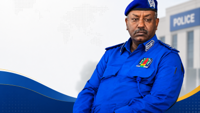 تصميم إخباري يظهر مسؤولاً شرطياً سودانياً بخلفية مخصصة لمقال حول اتهامات بفرض رسوم غير قانونية داخل قسم شرطة المهدية