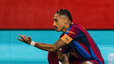 صورة احترافية للاعب نادي برشلونة رافينيا وهو يحتفل بتركيز على أرضية الملعب بعد إحرازه هدفاً، مرتديياً قميص البلوغرانا مع شارة القيادة، وذلك خلال مباراته الحاسمة ضد نادي إشبيلية في الدوري الإسباني.