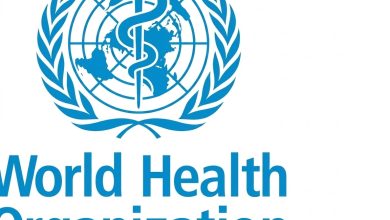 شعار منظمة الصحة العالمية (WHO): رمز عصا أسكليبيوس والأفعى محاطاً بغصني زيتون وخريطة العالم، باللون الأزرق على خلفية بيضاء.⁠