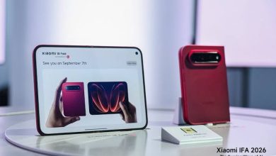 "هاتف Xiaomi 18 Fold القابل للطي الأحمر في معرض Xiaomi IFA 2026 مع لوحة إعلانية تعرض تاريخ الإطلاق."